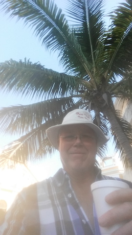 The writer and his coffee under a palm tree